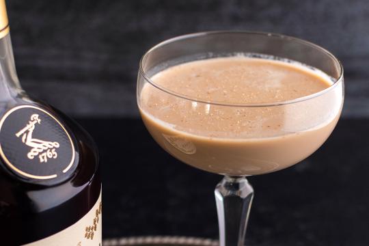 A creamy brown cocktail served in a coupe glass and dusted with nutmeg, styled for The Speakeasy Podcast to showcase a rich and elegant drink pairing.