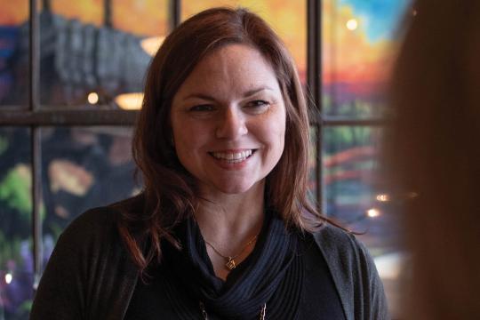 Jen, co-host of Speak Easy Podcast, professional portrait in restaurant setting with window lighting
