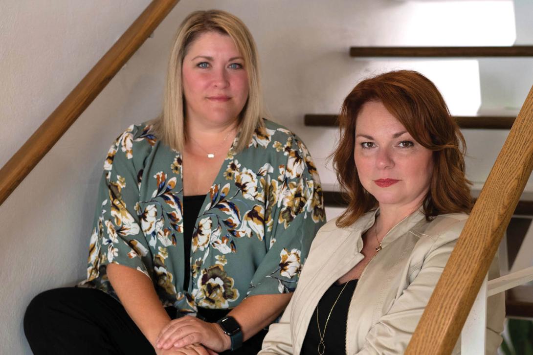 Picture of Karen and Jen sitting on a staircase, facing the camera.